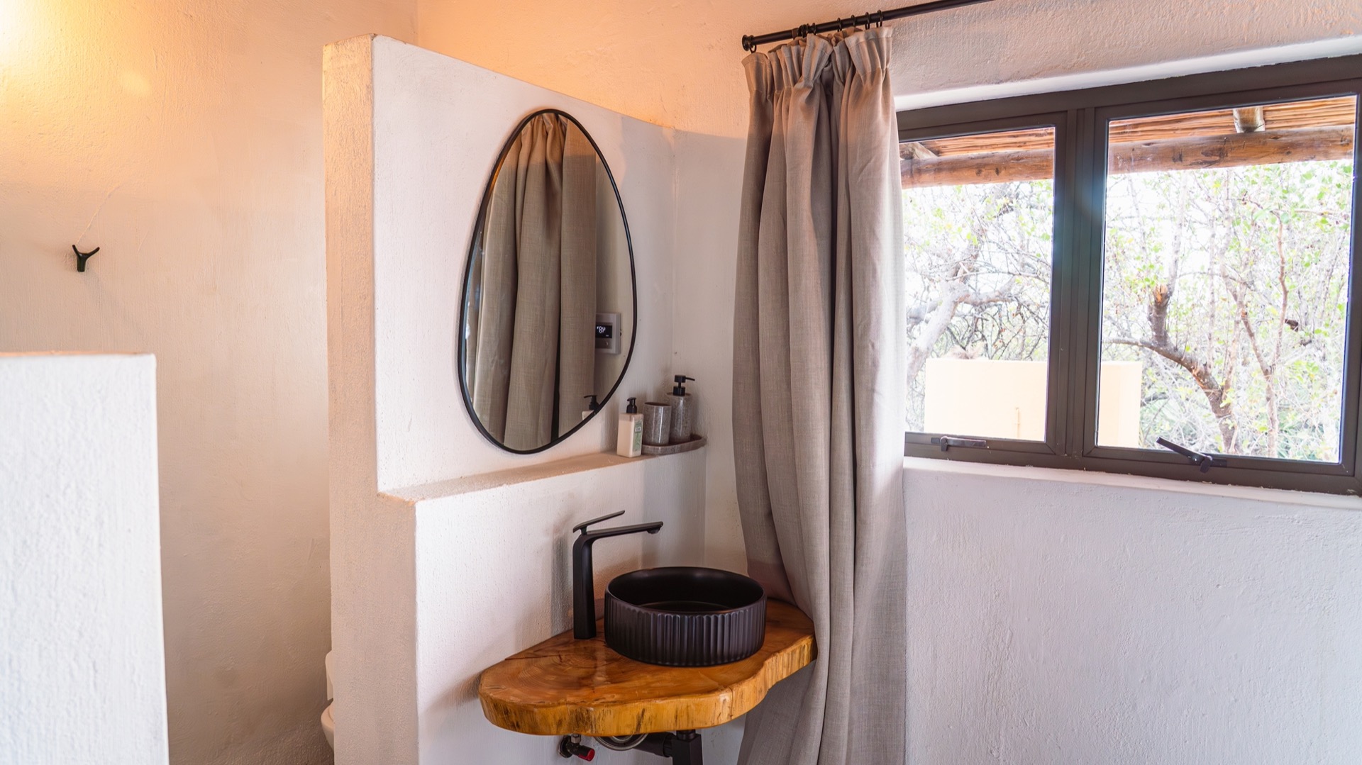 Live-edge vanity with a black basin and round mirror