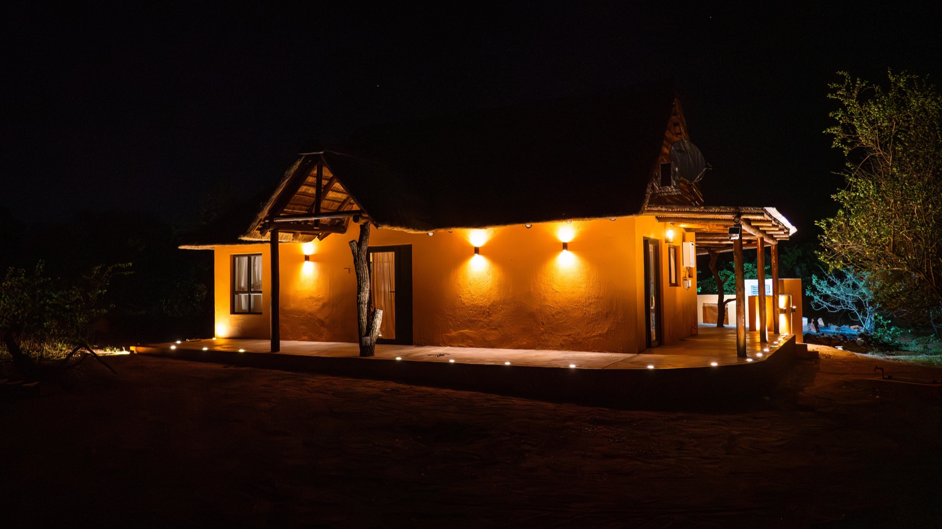 North Villa lit warmly against the night bush