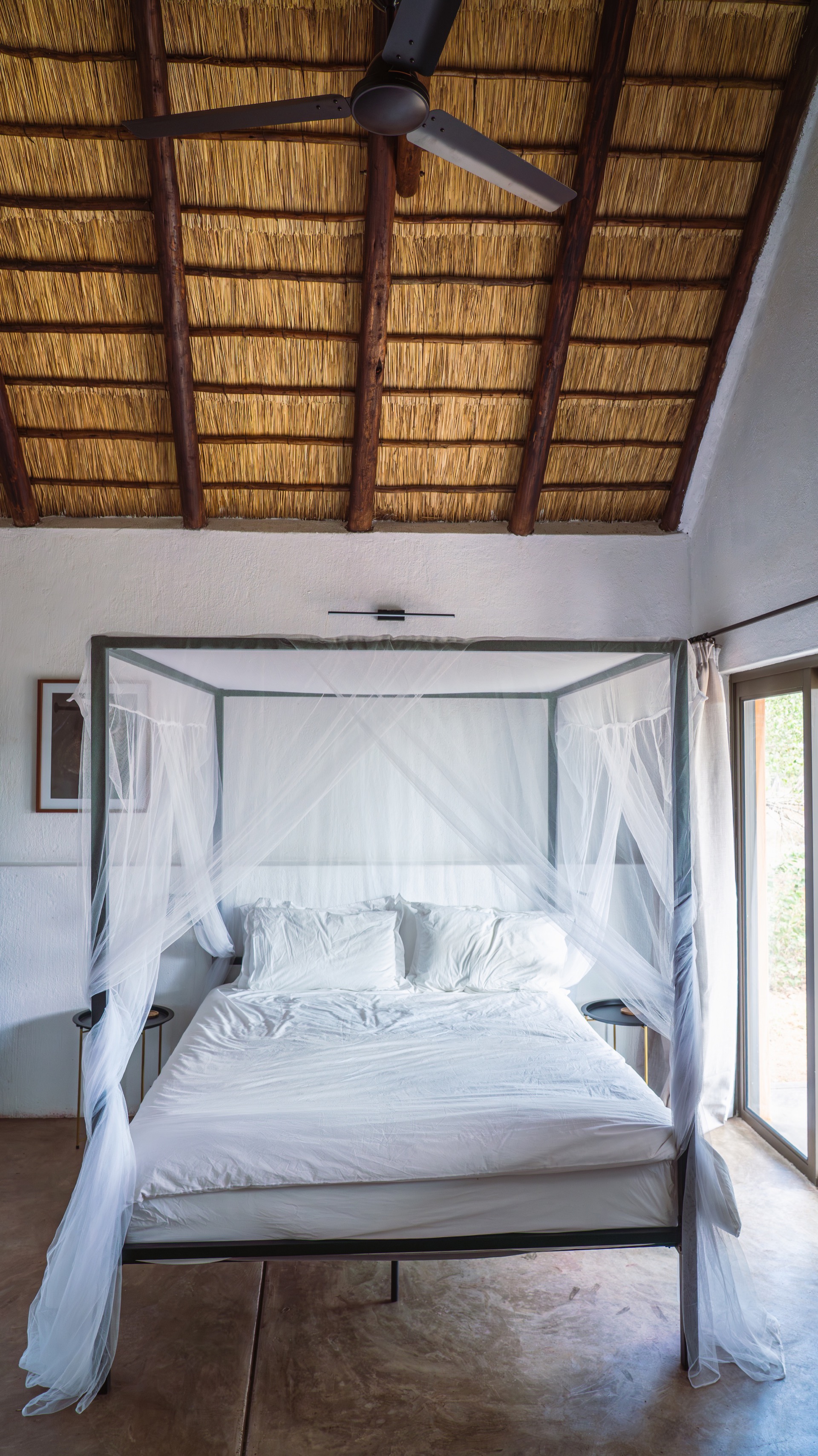 Queen bedroom with a canopy mosquito net under the thatch